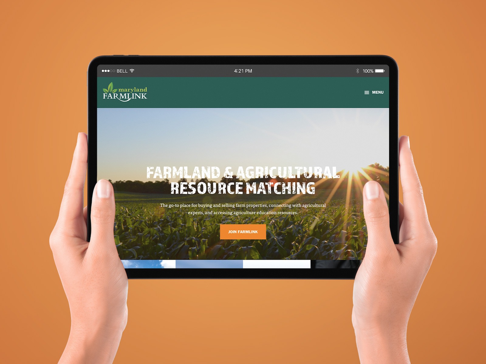 Hands holding a tablet displaying a website for 