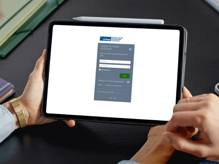 A person holds a tablet displaying a login screen for the 