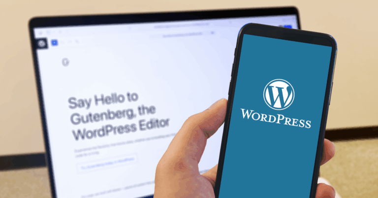 A person holds a smartphone displaying the WordPress logo in front of a laptop screen showing the message, 